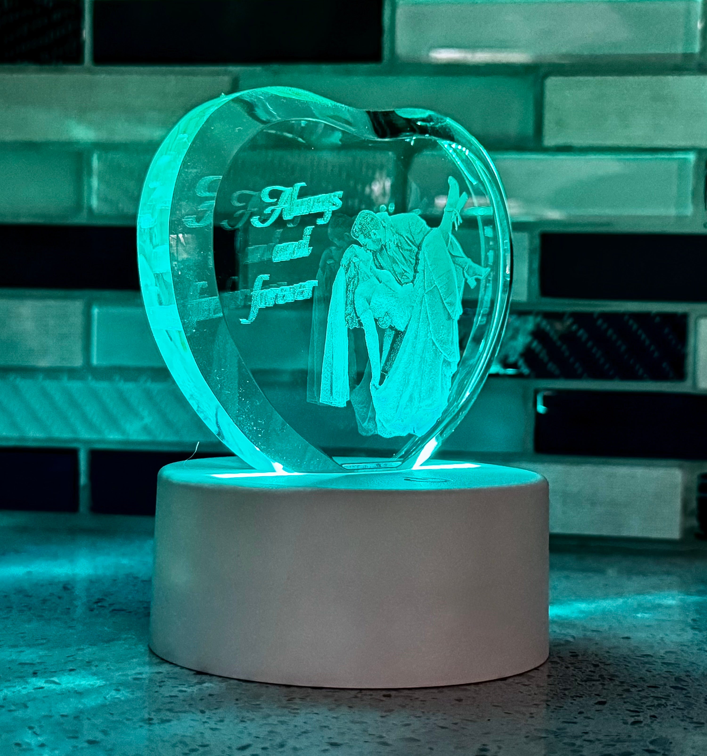 Heart-shaped LED lamp with engraved design and text on a reflective surface.